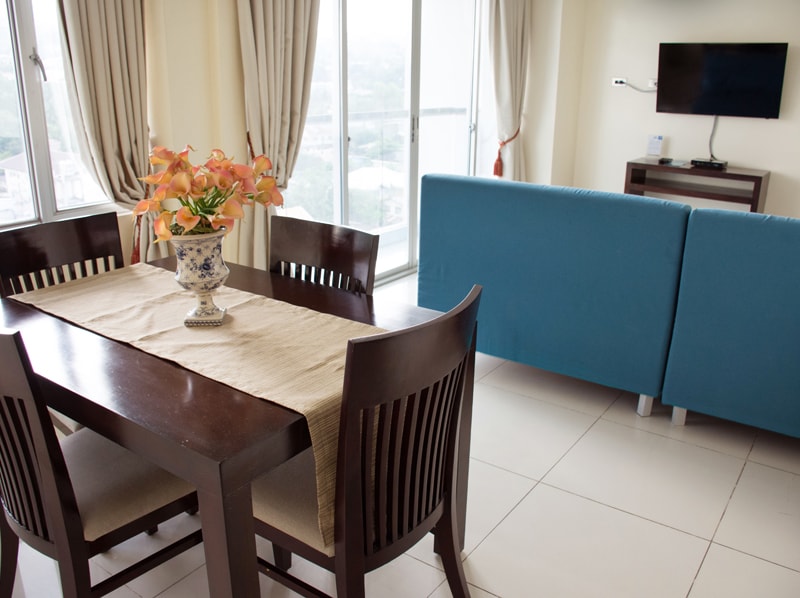 セブ島のアリシアアパーテルの客室　ツーベッドルームデラックスのテーブルとソファ